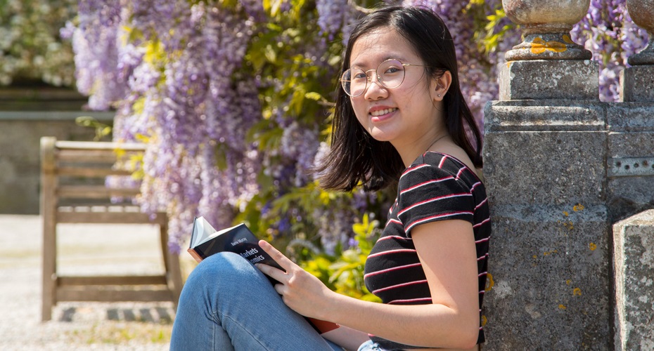 Student sat in front of flowers