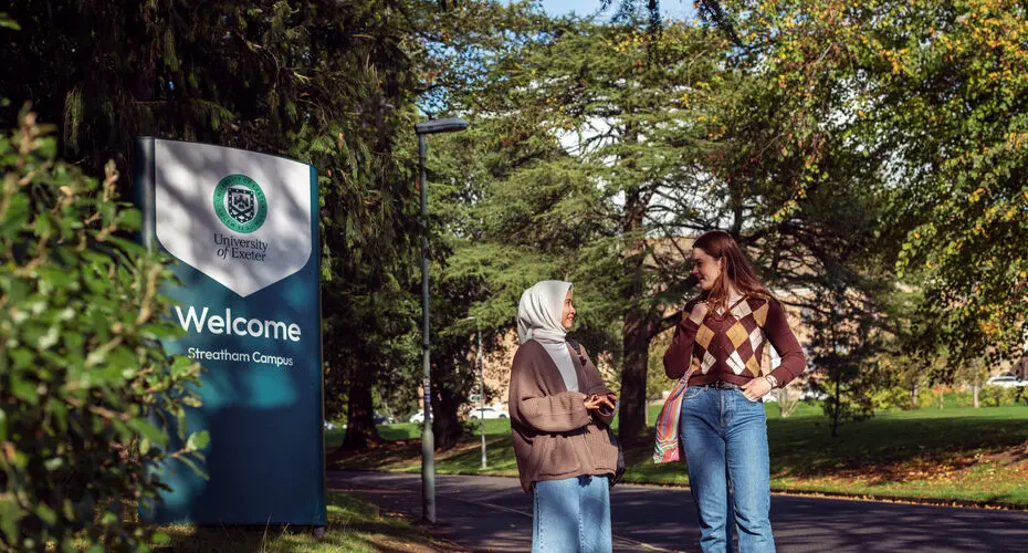 Two students talking on their way to Streatham Campus in Exeter.